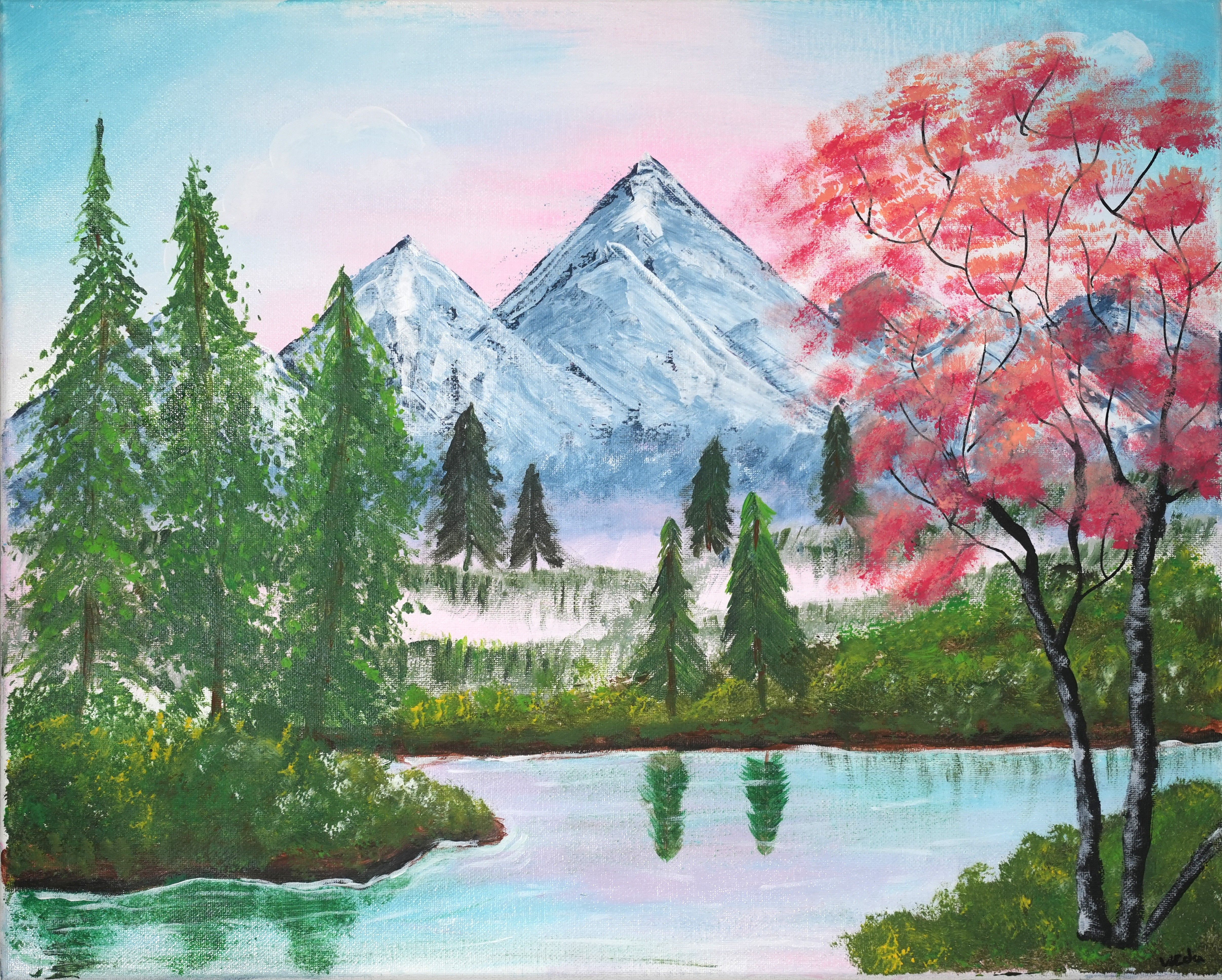 Pink cherry blossoms frame a mountain lake.